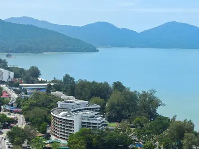 a large building next to a large body of water at Seri Sayang Seaview Resort Batu Ferringhi in Batu Ferringhi