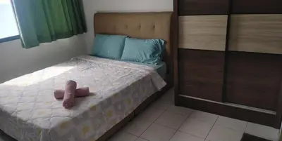 a teddy bear sitting on a bed in a bedroom at Seri Sayang Seaview Resort Batu Ferringhi in Batu Ferringhi