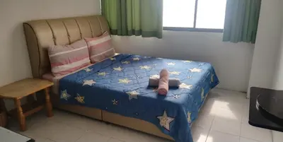 a small bedroom with a bed with a blue comforter and stars at Seri Sayang Seaview Resort Batu Ferringhi in Batu Ferringhi
