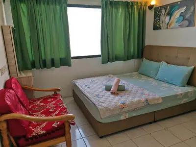 a small bedroom with a bed and a chair at Seri Sayang Seaview Resort Batu Ferringhi in Batu Ferringhi