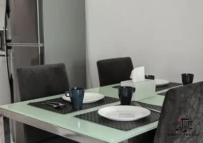 a green table with chairs and a plate on it at Mansion One by Simply Penang in George Town