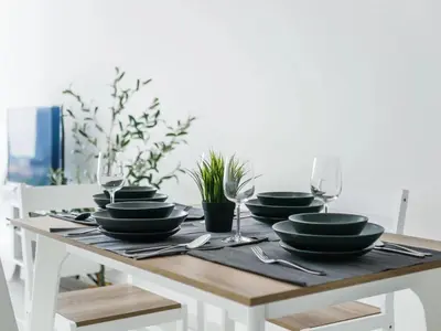 a wooden table with black plates and wine glasses at BEACON LeNa #Seaview#RoofTopPool#6pax#Georgetown in George Town