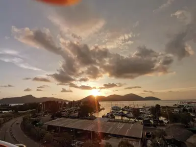 a sunset over a marina with boats in the water at Spacious & Homey Apartment at Marina Island by JoMy Homestay in Lumut