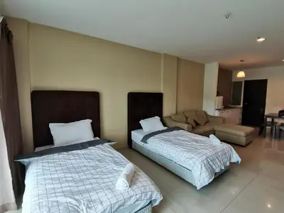a room with two beds and a couch in it at Spacious & Homey Apartment at Marina Island by JoMy Homestay in Lumut