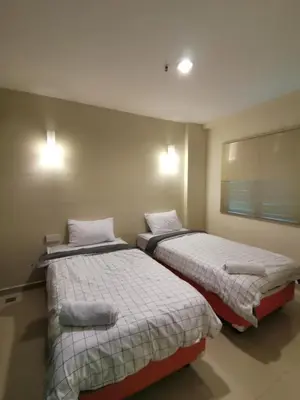 two beds in a room with at Spacious & Homey Apartment at Marina Island by JoMy Homestay in Lumut