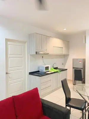 a living room with a red couch and a kitchen at Mansion One Seaview Luxury 2 Bedroom Gurney Georgetown gleneagles in George Town