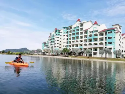 a man in a kayak in the water in front of a building at Marina Island Ocean Theme @ Lumut Sitiawan in Lumut