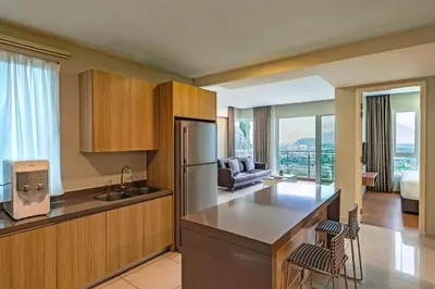 a kitchen with a refrigerator and a living room at TUI BLUE The Haven Ipoh in Ipoh