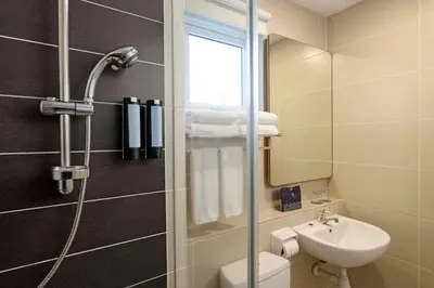 a bathroom with a shower and a toilet and a sink at TUI BLUE The Haven Ipoh in Ipoh