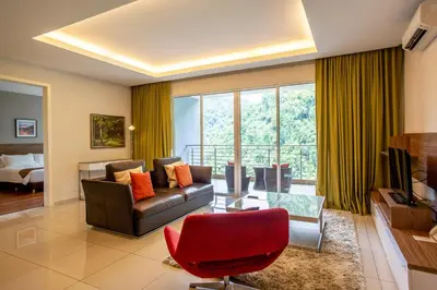 a living room with a couch and a red chair at TUI BLUE The Haven Ipoh in Ipoh