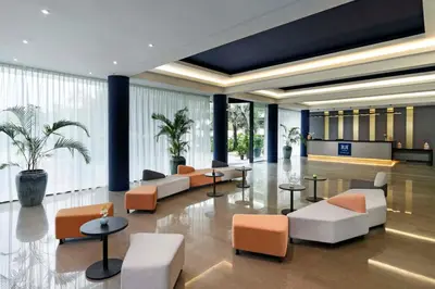 a lobby with orange and white furniture and large windows at TUI BLUE The Haven Ipoh in Ipoh