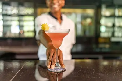 a hand holding a drink with a flower in it at TUI BLUE The Haven Ipoh in Ipoh