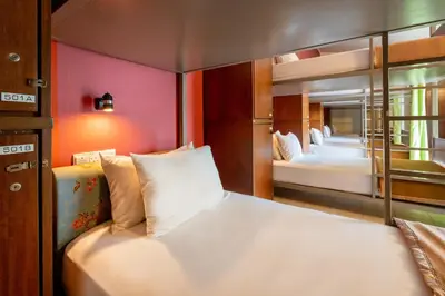 a bedroom with two beds and a mirror at Victoria Inn, Penang in George Town
