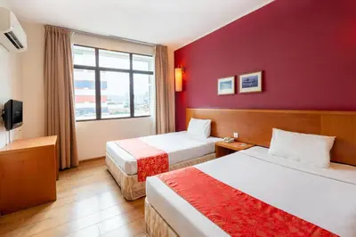 a hotel room with two beds and a window at Victoria Inn, Penang in George Town