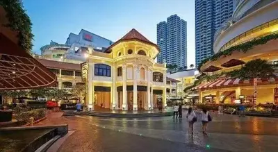 a group of people walking in a city with buildings at Amazing Home Inn in George Town