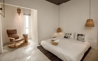 a bedroom with a bed and a chair and a window at Amazing Home Inn in George Town