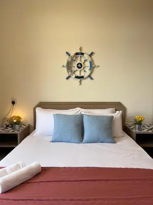 a bedroom with a bed with a steering wheel on the wall at EE's Summer House - Homestay 3 min walk to beach in Batu Ferringhi