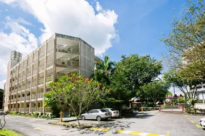a building with cars parked in a parking lot at EE's Summer House - Homestay 3 min walk to beach in Batu Ferringhi