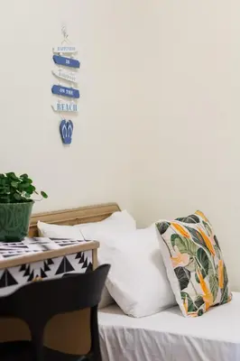 a bedroom with a bed with pillows and a table at EE's Summer House - Homestay 3 min walk to beach in Batu Ferringhi
