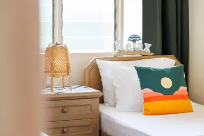 a small bedroom with a bed and a window at EE's Summer House - Homestay 3 min walk to beach in Batu Ferringhi