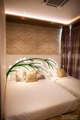 a bedroom with two beds with a tree headboard at Pearl Rice Garden (European Style) in Sekincan