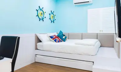 a couch in a room with a blue wall at Pearl Rice Garden (European Style) in Sekincan