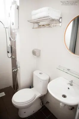 a white bathroom with a toilet and a sink at Pearl Rice Garden (European Style) in Sekincan