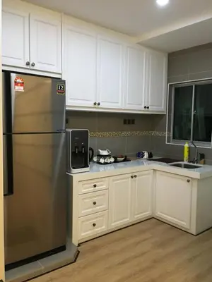 a kitchen with white cabinets and a stainless steel refrigerator at Pearl Rice Garden (European Style) in Sekincan