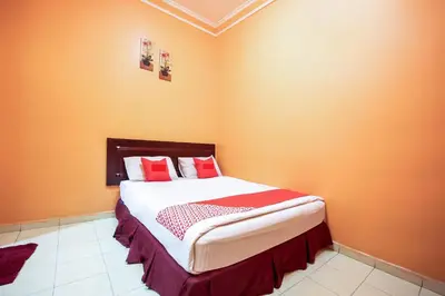 a bedroom with a large bed with orange walls at Ipoh Times Inn Hotel in Ipoh