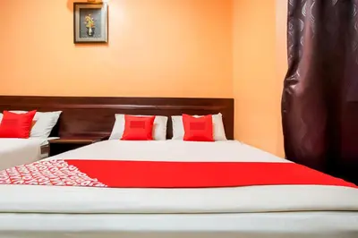 a bedroom with two beds with red pillows at Ipoh Times Inn Hotel in Ipoh