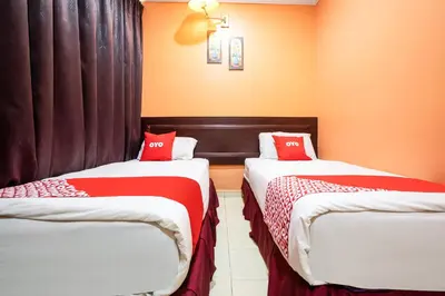 two beds in a room with red and white sheets at Ipoh Times Inn Hotel in Ipoh