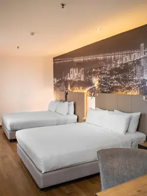 a hotel room with two beds and a painting on the wall at Travelodge Georgetown, Penang in George Town
