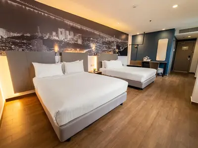a hotel room with two beds and a television at Travelodge Georgetown, Penang in George Town