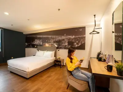 a woman sitting in a chair in a hotel room at Travelodge Georgetown, Penang in George Town