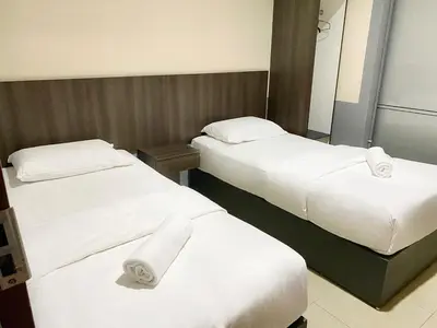 two beds in a hotel room with white sheets and towels at Chemor Inn in Cemur