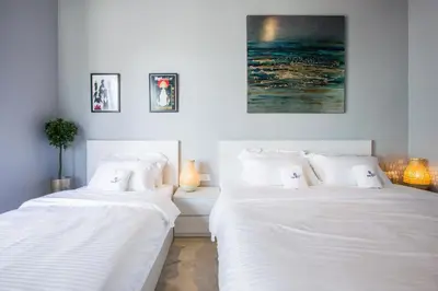 two beds in a room with white sheets at Beachboy Chalet By The Beach in Bukit Lada