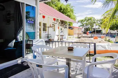 a white table and white chairs on a patio at Beachboy Chalet By The Beach in Bukit Lada