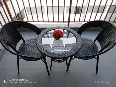 two chairs and a glass table with a vase on it at BC Homestay @ Emerald Avenue Apartment, Brinchang in Brinchang