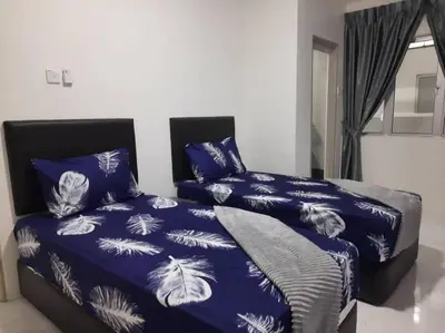a bedroom with two beds with blue and white sheets at BC Homestay @ Emerald Avenue Apartment, Brinchang in Brinchang