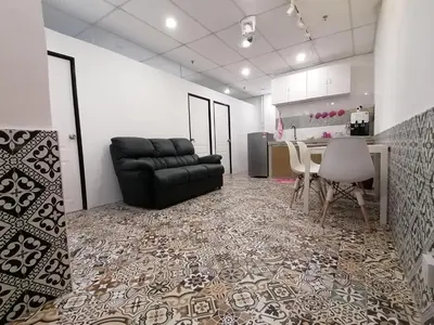 a living room with a black leather couch and a table at Fastbook Ferringhi SoHo unit 8pax in Batu Ferringhi