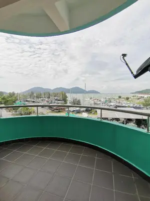 a balcony with a green railing and a view of a parking lot at Peaceful 1-bedroom unit at Marina Island by JoMy Homestay in Lumut