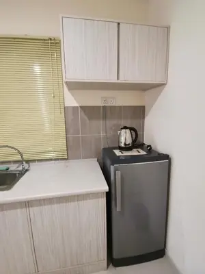 a kitchen with a black refrigerator and a sink at Peaceful 1-bedroom unit at Marina Island by JoMy Homestay in Lumut