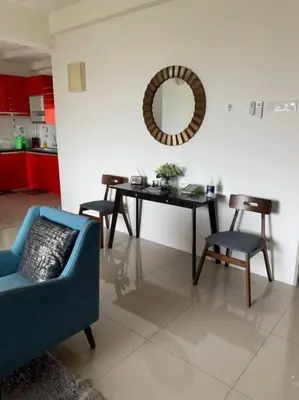 a living room with a table and chairs and a mirror at Lizs Homestay in Ipoh