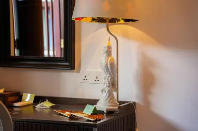 a bird sitting on a lamp on a desk at East Indies Mansion in George Town