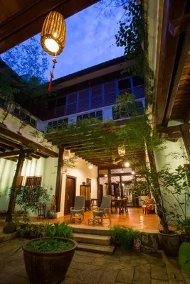 a building with a patio with chairs and a chandelier at East Indies Mansion in George Town
