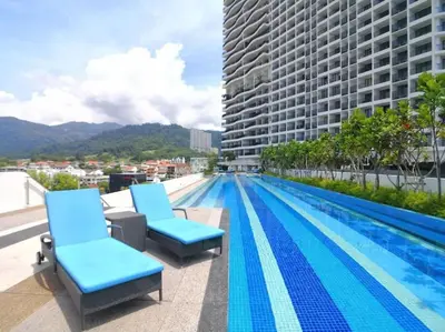 a swimming pool with blue chairs on the roof of a building at Large Family Seaview Suite 3 Rooms by The Only Bnb in Tanjong Tokong