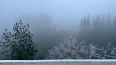 a building in the fog with trees in the background at THE MILKY WAY @ PINE RESORT in Bukit Fraser