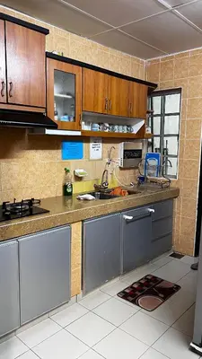a kitchen with wooden cabinets and stainless steel appliances at THE MILKY WAY @ PINE RESORT in Bukit Fraser
