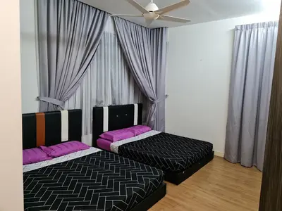 two beds in a room with a ceiling fan at Pearl Residences Sleep 27 in Batu Ferringhi