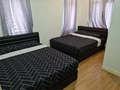 two beds sitting next to each other in a bedroom at Pearl Residences Sleep 27 in Batu Ferringhi
